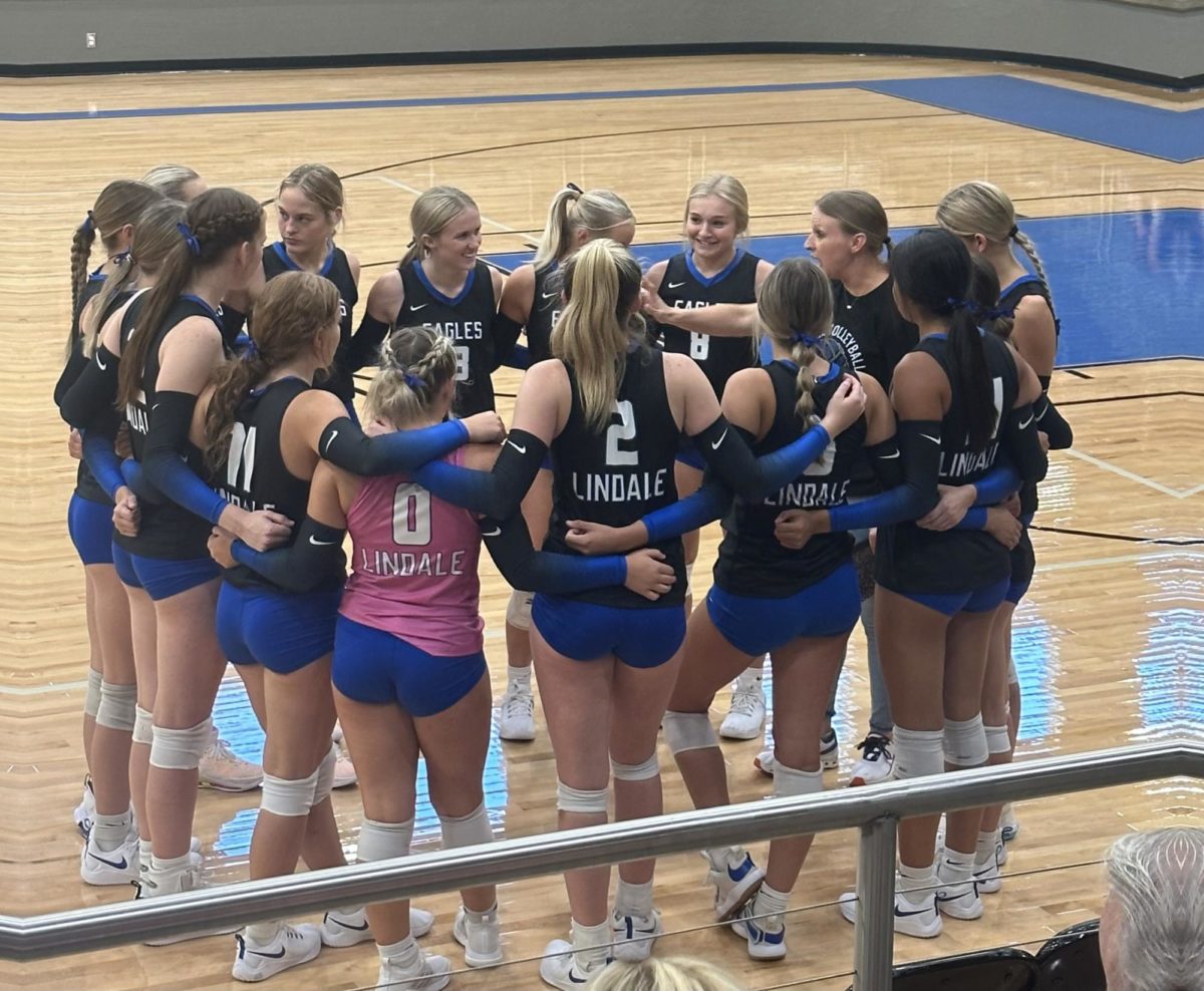The varsity volleyball team huddles before a game. We have a lot of team players and definitely play as a team, head coach Jessica Camp said.