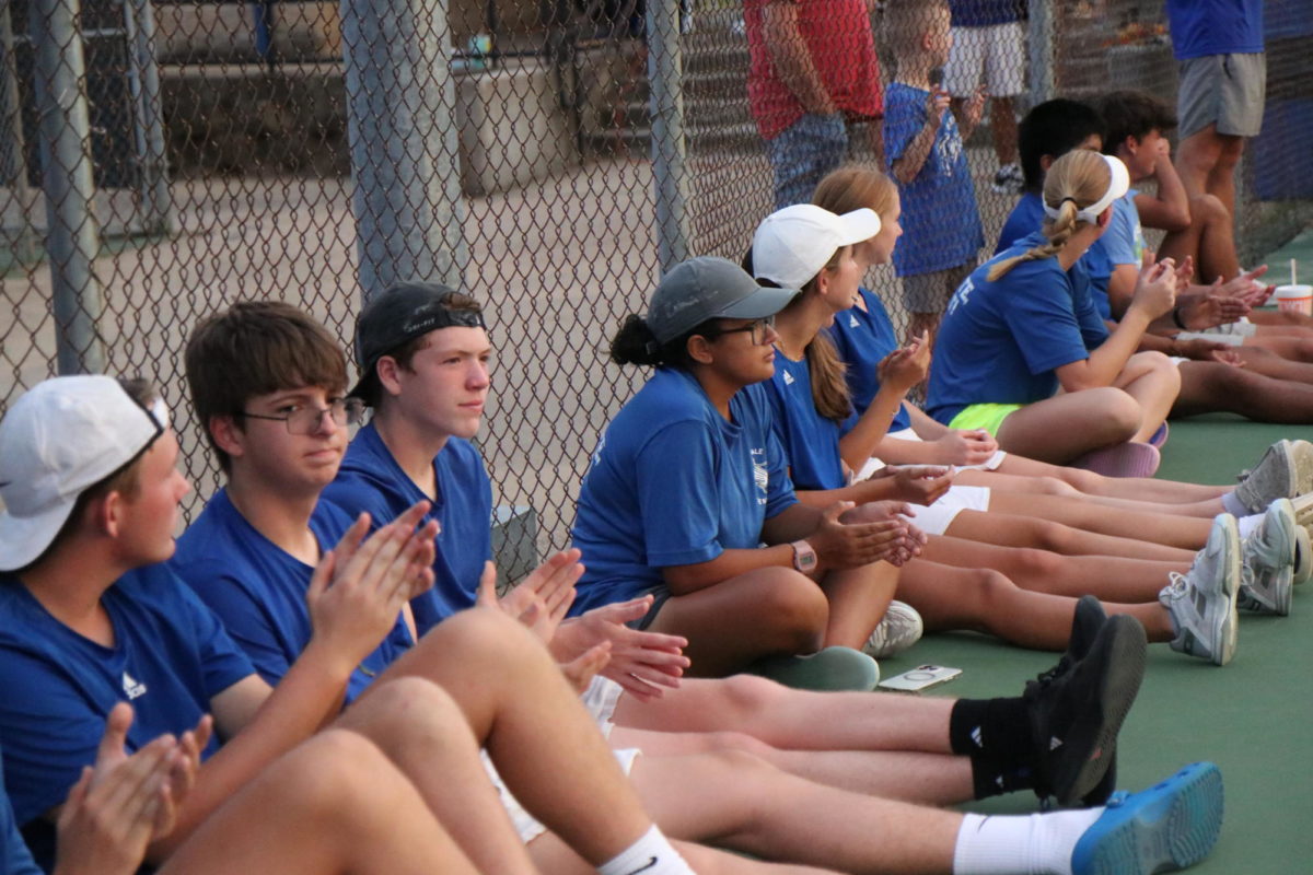 Tennis+Team+sits+on+side+of+court+waiting+for+game+to+begin.+Tennis+games+are+between+two+people%2C+or+two+teams+with+two+people+on+each+team.