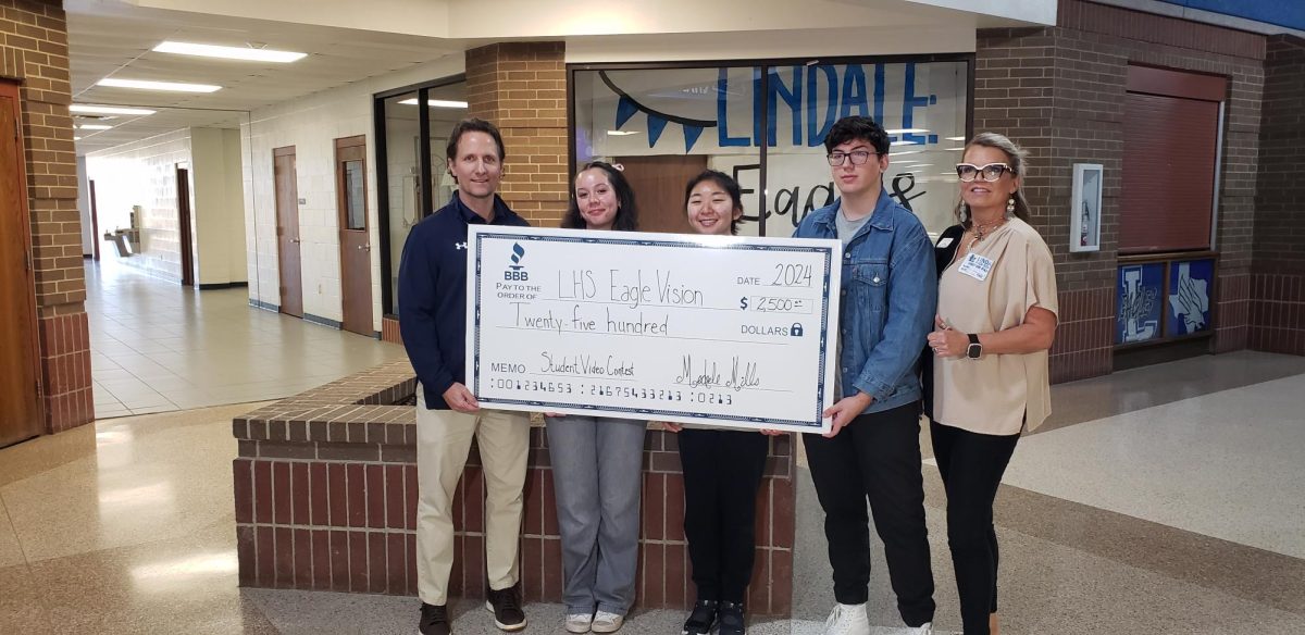 Members of the EagleVision film team hold up their $2500 check from the better Business Bureau. I wanted to give my class a chance to receive funding for us to do more fun stuff, senior Liliana Miller said.