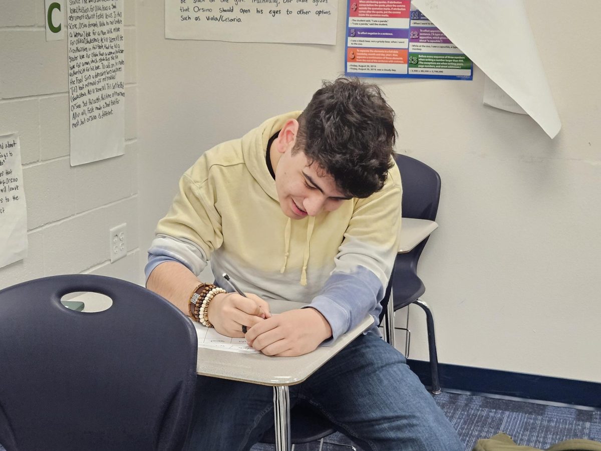 Junior Andrew Kinsel writes descriptions during the latest Creative Writing Club meeting. Students were given Hershey kisses and cotton pads to describe.