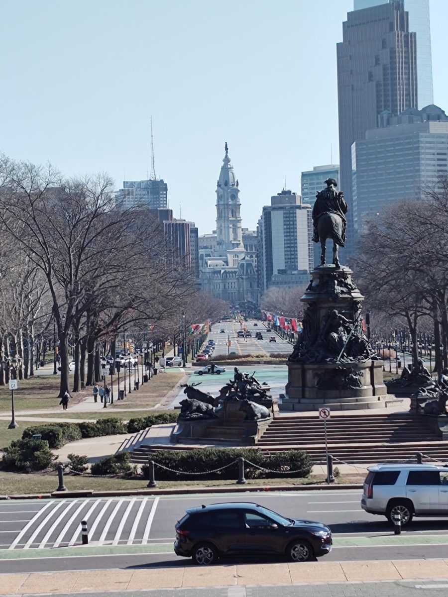 The famous Eakins Oval statue on the main street of Philly. In the background showcases the city hall as well as the flags that decorate the sides of main street.
