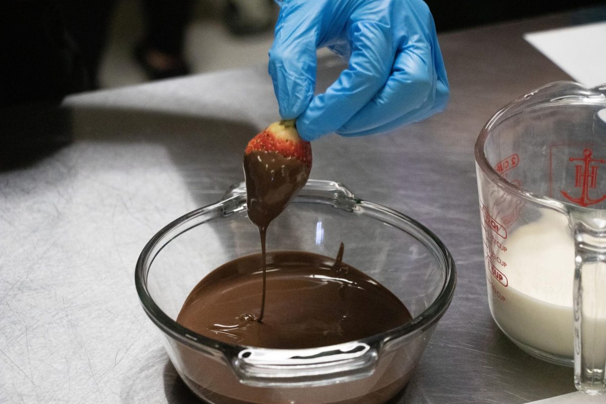 Culinary student dips a strawberry in chocolate. The students did these for Valentines Day.