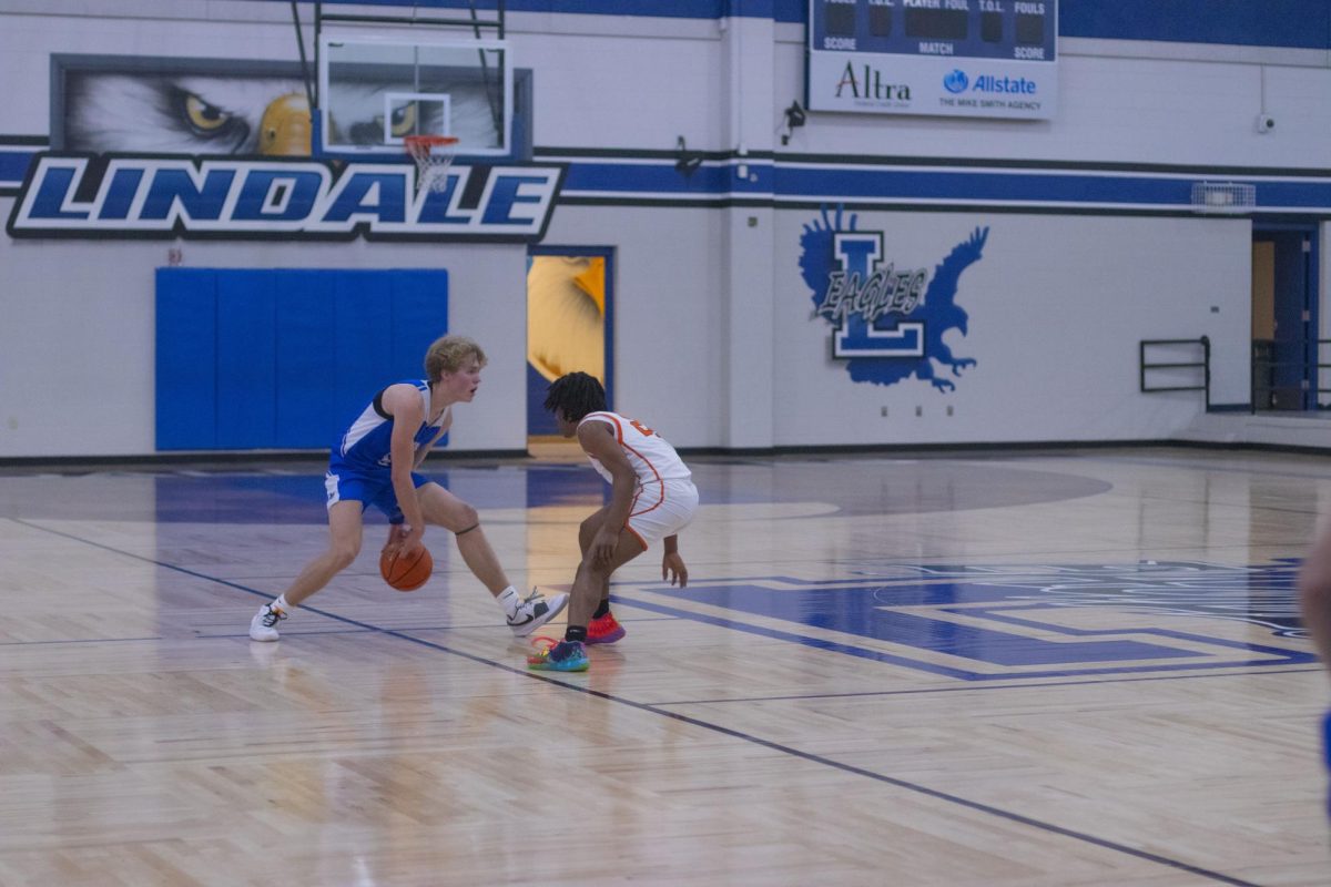 Senior Cole Collingsworth dribbles the ball down the court against an opposing player. He was awarded with the title of 1st Team all District. 