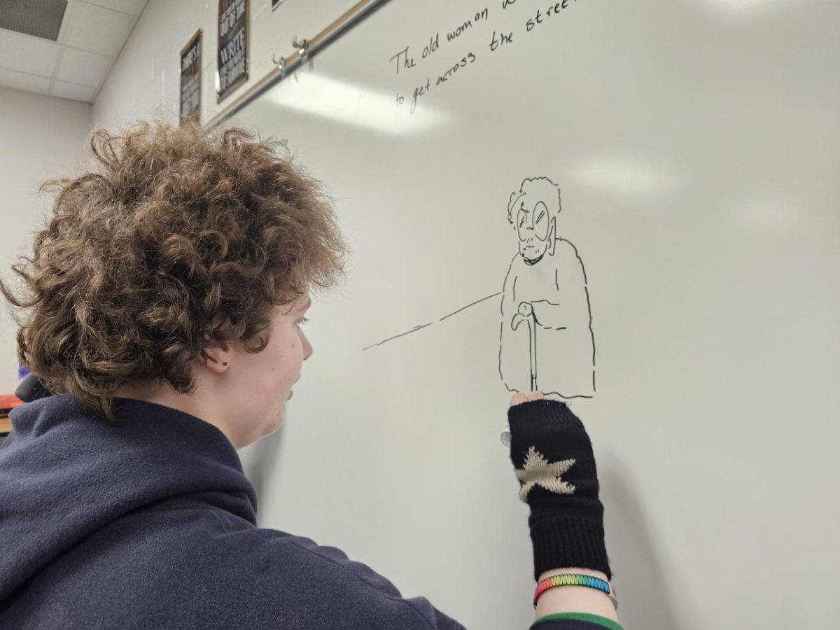 Sophomore Eva Gardner draws an image of an elderly lady during the last Creative Writing Club meeting. She was instructed to draw a picture of an elderly woman trying to get home for a show dont tell project.