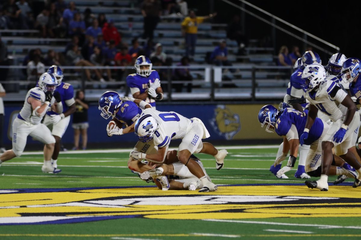 Senior Nathan Bradford tackles bulldog running back at about the 50 yard line. Bradford plays the position of line backer and tight end. 