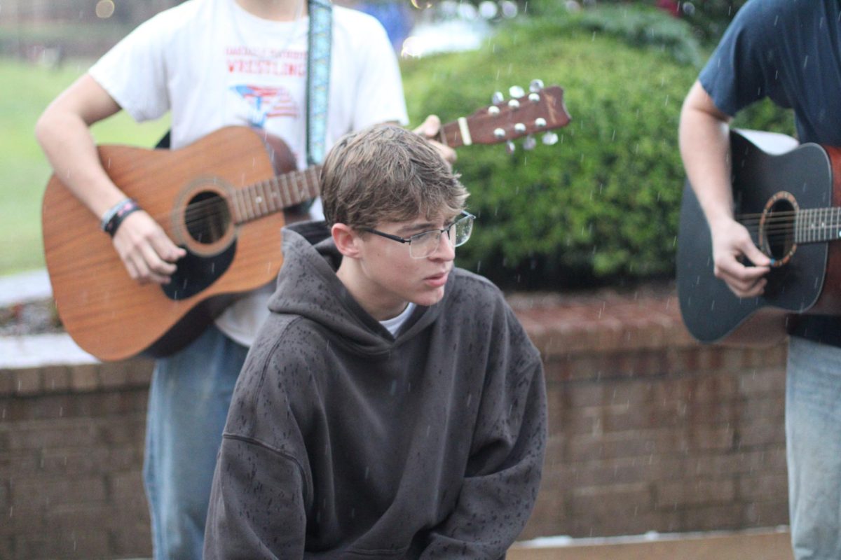 Senior Hudson Kinney plays the cajon with the worship team. He later moved into the lecture hall to continue worship after it started raining.