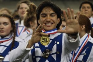 Junior squad leader Joshua Edwards poses with his medal and his hand holding up a five in reference to the band's five year streak of winning gold at the 4A UIL Military Marching Band Competition. "Continuing the legacy and streak of our high-school band has to be one of the most exciting feelings," Edwards said. "The suspense building up to the moment where Lindale was announced champion had to be one of the most exhilarating experiences I've had despite knowing that our performance was incredible."